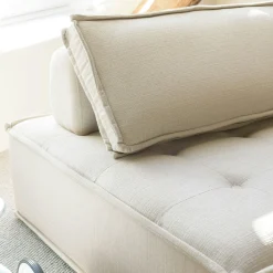 Fauteuil chauffeuse tissu capitonné beige avec coussin